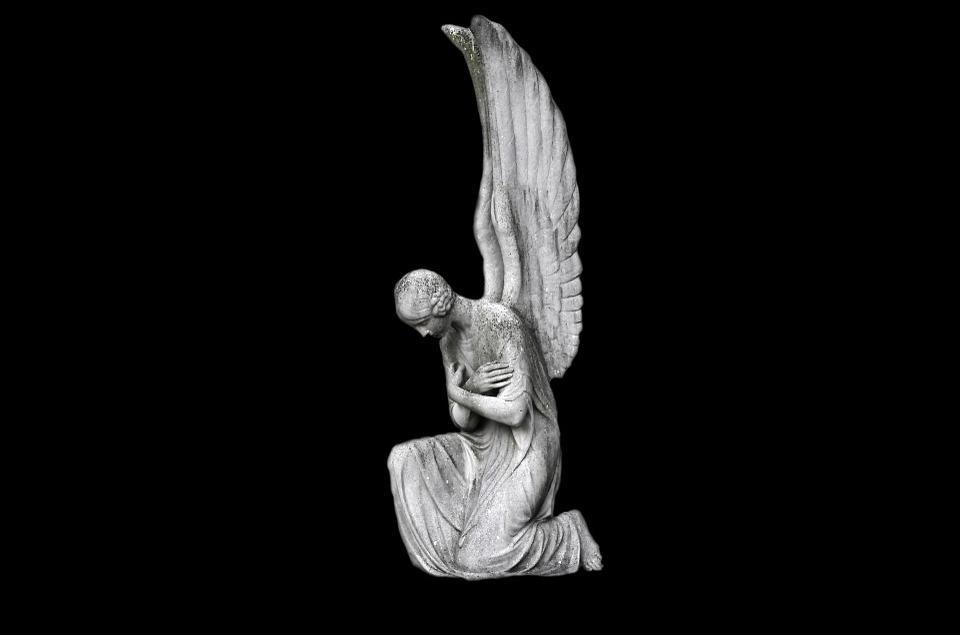 1001 nombre d'anges - statue d'ange génuflexion sur fond sombre